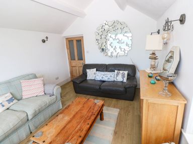 A living room with a sofa and coffee table at Y Glyn in Borth