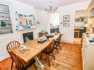 A dining room with a wooden table and chairs at Y Glyn in Borth