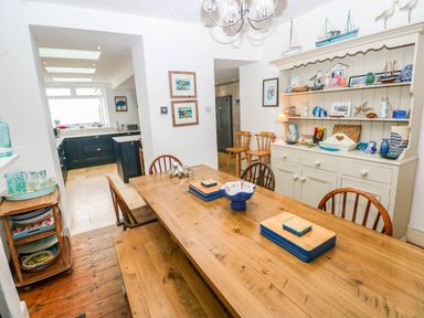 A dining room with a wooden table and chairs at Y Glyn Borth