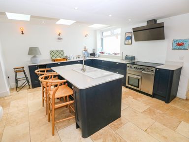 A kitchen with an island and stove at Y Glyn in Borth