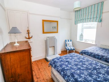 A bedroom with two beds and a lamp at Y Glyn in Borth