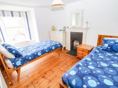 A bedroom with two beds and a chest of drawers at Y Glyn in Borth