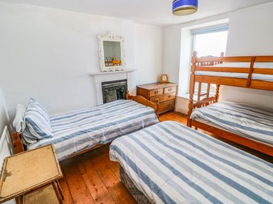 A bedroom with two beds and a bunk bed at Y Glyn Borth