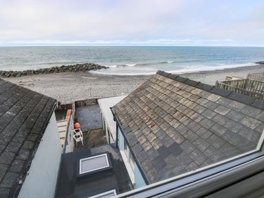 An outdoor view of a beach and sea from a property at Y Glyn in Borth