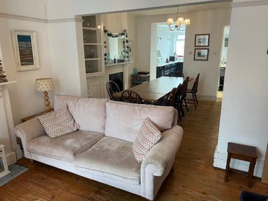 A living room with a sofa and dining area at Y Glyn in Borth