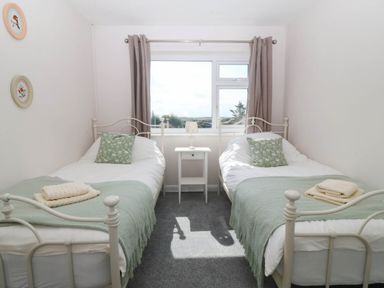 A bedroom with two beds and a window at Wilpol in Llanerchymedd