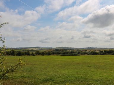 A landscape view of a field with hills in the background at Wilpol in Llanerchymedd