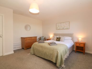 A bedroom with a bed and nightstands at Wilpol in Llanerchymedd