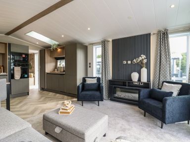 A living room with a sofa and two armchairs at Lodge 8 St. Osyth