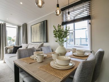 A dining room with a table set for dinner at Lodge 8 St. Osyth