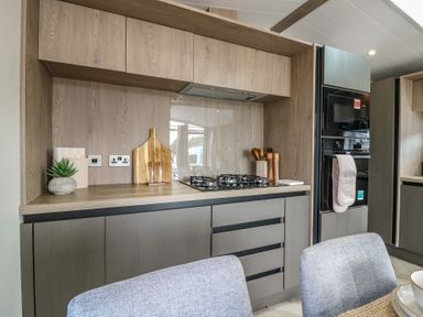 A kitchen with cabinets and appliances at Lodge 8 St. Osyth