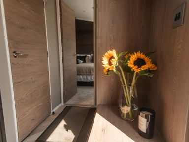 A hallway with sunflowers in a vase and a candle at Lakewood Plot 4 St. Osyth