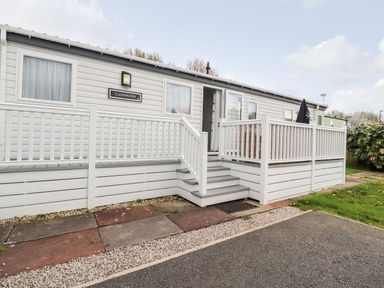 An outdoor view of a cabin with steps and a handrail at Clearwater in Morecambe