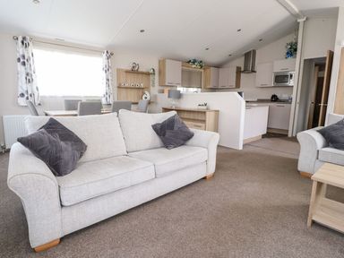 A living room with a sofa and dining area at Rosella 38 Morecambe