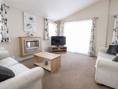 A living room with a sofa and television at Rosella 38 Morecambe