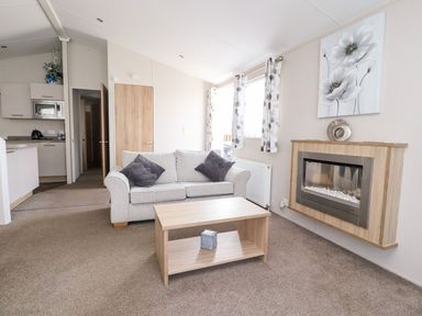 A living room with a sofa and coffee table at Rosella 38 in Morecambe
