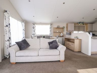A living room with a sofa and dining area at Rosella 38 in Morecambe