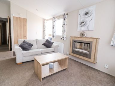A living room with a sofa and coffee table at Rosella 38 in Morecambe
