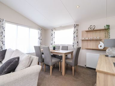 A dining room with a table and chairs at Rosella 38, Morecambe