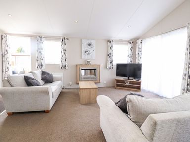 A living room with sofas and a television at Rosella 38 in Morecambe