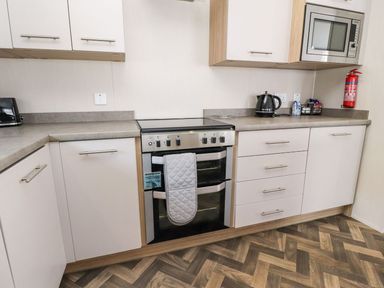 A kitchen with an oven and microwave at Rosella 38 Morecambe