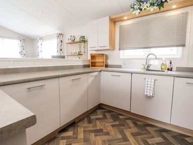 A kitchen with cabinets and a sink at Rosella 38 in Morecambe
