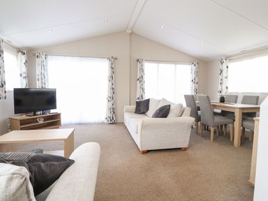 A living room with a sofa and dining area at Rosella 38 in Morecambe