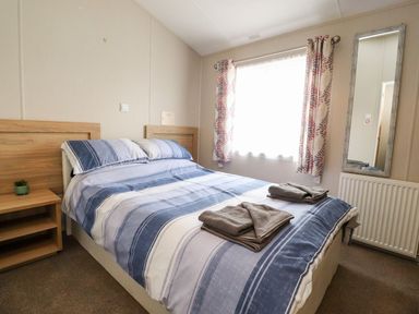 A bedroom with a bed and bedside table at Rosella 38 in Morecambe