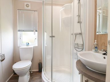 A bathroom with a shower, toilet, and sink at Rosella 38 Morecambe