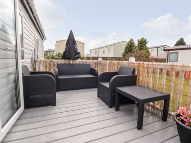 An outdoor seating area with chairs and a table at Rosella 38 in Morecambe