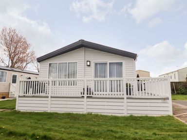 A mobile home with a porch and grass at Rosella 38 Morecambe