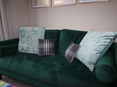 A couch with decorative pillows in a living room at Brinkburn House, Scarborough