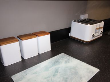 A kitchen counter with a toaster and storage containers at Brinkburn House in Scarborough