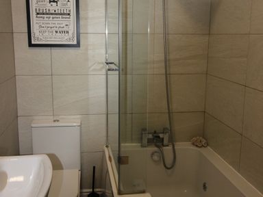 A bathroom with a bathtub, toilet, and sink at Brinkburn House in Scarborough