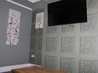 A living room with a television and wall art at Blackburn Heights Apartment 1 in Bridlington