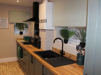 A kitchen with appliances and plants at Blackburn Heights Apartment 1 in Bridlington