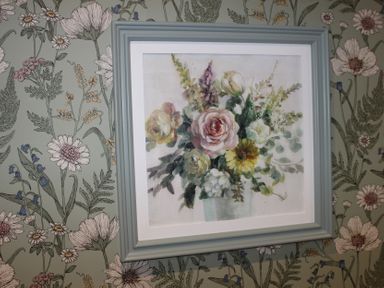 A floral painting framed on wallpaper at Blackburn Heights Apartment 1 in Bridlington