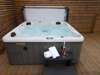 A hot tub with towels and wine glasses in an outdoor area at Blackburn Heights Apartment 1, Bridlington