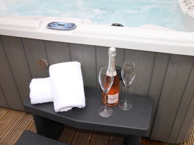 A hot tub with towels and champagne in an outdoor area at Blackburn Heights Apartment 1 in Bridlington