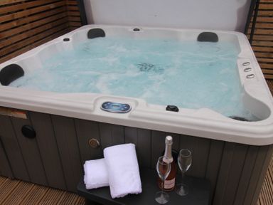 A hot tub with champagne glasses and towels at Blackburn Heights Apartment 1 in Bridlington