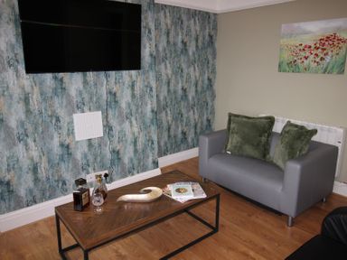 A living room with a sofa and a coffee table at Cornerhouse Apartment 1 in Llandudno