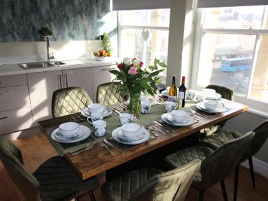 A dining room with a table set for a meal at Cornerhouse Apartment 1, Llandudno