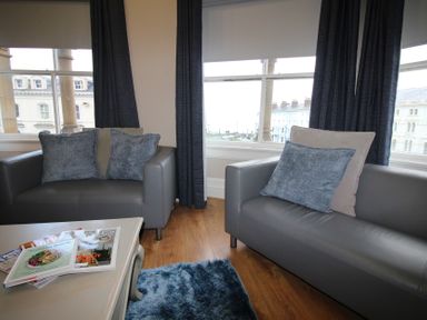 A living room with armchairs and a coffee table at Cornerhouse Apartment 2 in Llandudno