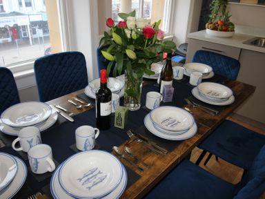 A dining room table set with plates and cutlery at Cornerhouse Apartment 2 in Llandudno