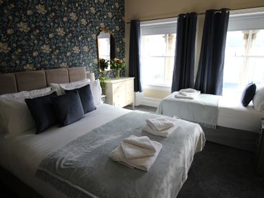 A bedroom with two beds and a dresser at Cornerhouse Apartment 2 Llandudno