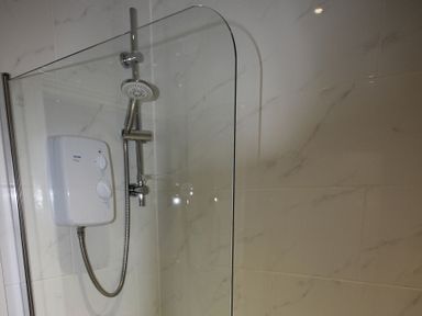 A shower with a control unit and showerhead at Cornerhouse Apartment 2 Llandudno