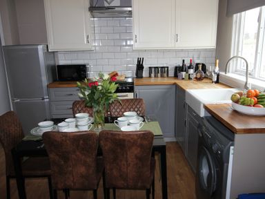 A kitchen with a dining table set for four at Cornerhouse Apartment 4 in Llandudno