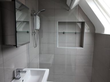 A bathroom with a sink and shower at Cornerhouse Apartment 4, Llandudno