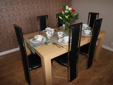 A dining room with a table set for meal at Cornerhouse Apartment 5 in Llandudno