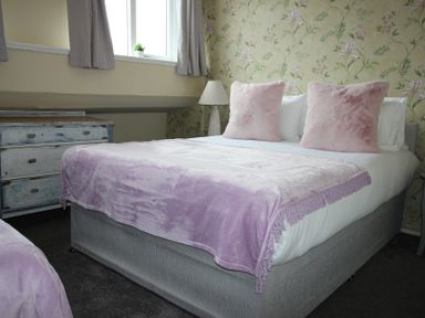 A bedroom with bed and dresser at Cornerhouse Apartment 5 in Llandudno